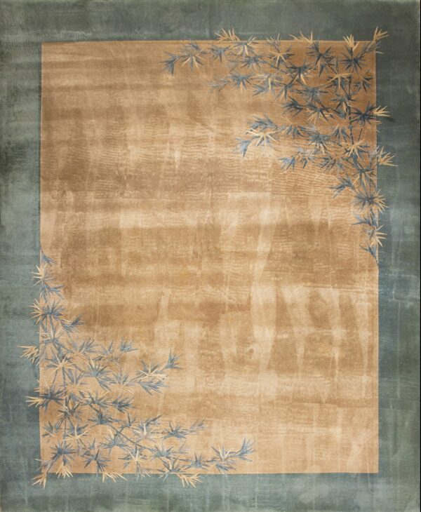 Tan rug with a teal border and stylized blue and gold bamboo leaf pattern near the corners.