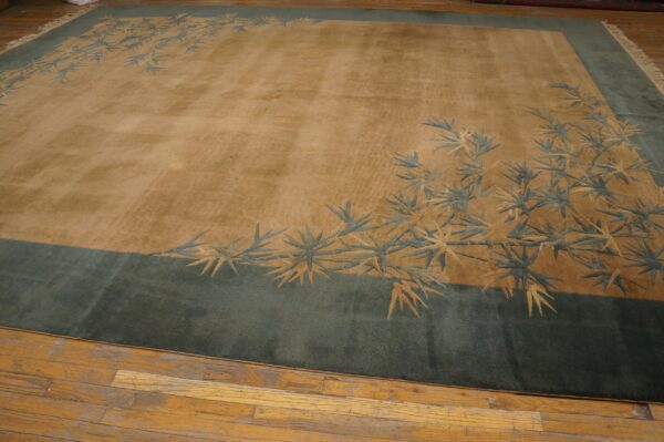 Low-pile tan and green rug featuring a bamboo motif, displayed on worn wooden flooring.