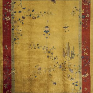 Golden yellow rug with a prominent rust red border and pale blue and white blossoming branches decorating the field.