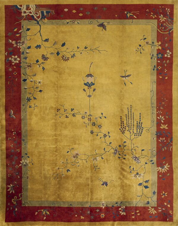 Golden yellow rug with a prominent rust red border and pale blue and white blossoming branches decorating the field.