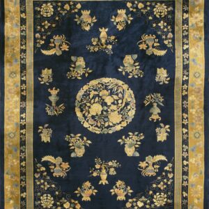 Deep blue rug featuring ornate gold, green, and pink floral patterns and a wide yellow border.