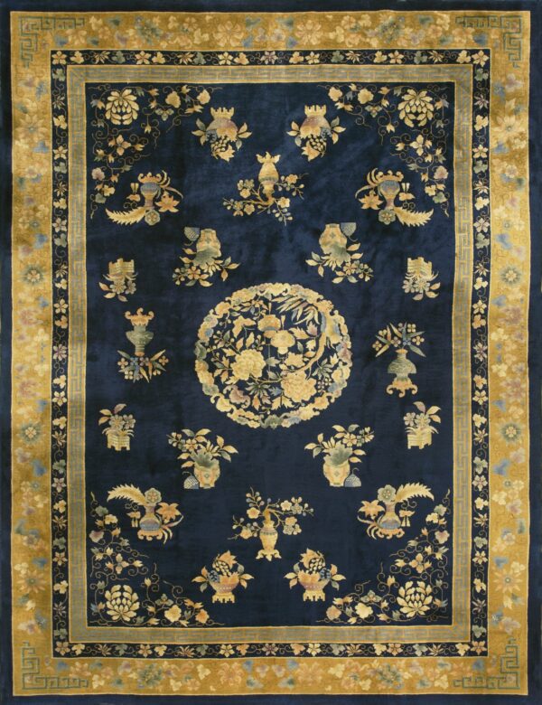 Deep blue rug featuring ornate gold, green, and pink floral patterns and a wide yellow border.
