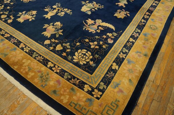 Deep navy blue rug featuring yellow and multi-color motifs and a complex gold border on wood planks.