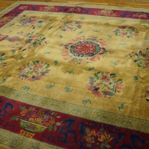 Lustrous yellow rug with a central medallion, vibrant floral sprays, and a dark red border on wood flooring.