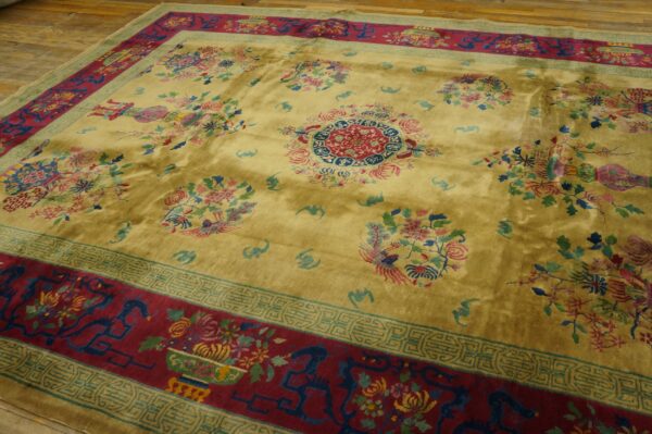 Lustrous yellow rug with a central medallion, vibrant floral sprays, and a dark red border on wood flooring.