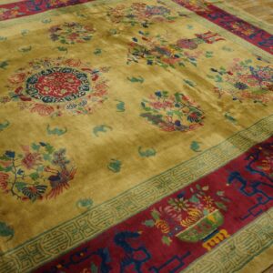 Plush olive-yellow rug displaying multicolor floral medallions and a wide red border with intricate geometric patterns.