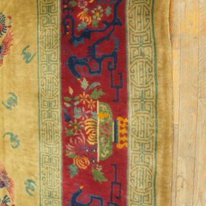 High-pile rug featuring a central red panel with florals, dark blue designs, and golden borders on wood.