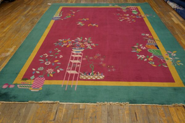 Magenta and teal rug with colorful floral motifs and a yellow stripe border resting on worn wood planks.