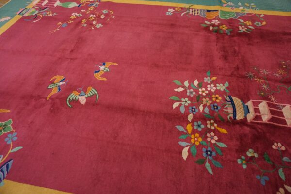 High-pile magenta rug featuring colorful floral designs, butterflies, and a teal and yellow border.