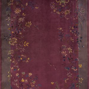 Deep burgundy rug with a gray border and multicolored floral vines trailing across the edges.