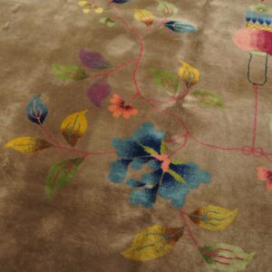 Plush taupe rug displaying colorful stylized floral and vine motifs in blue, yellow, green, and magenta.