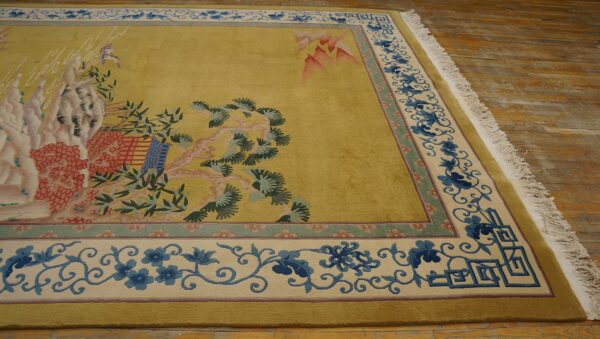 Chartreuse rug with a landscape pattern and intricate blue floral border rests on distressed wood planks.