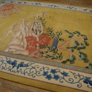 Chartreuse rug featuring a central motif of pink mountains and green foliage, framed by a blue and cream border.