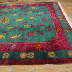 A vibrant teal and magenta rug with yellow phoenix and cloud motifs rests on distressed wood planks.