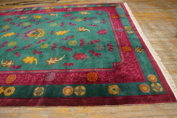 A vibrant teal and magenta rug with yellow phoenix and cloud motifs rests on distressed wood planks.