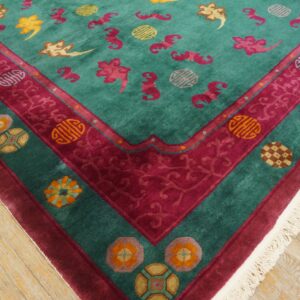 Teal rug with high pile features scattered pink and yellow motifs and ornate magenta borders on wood flooring.