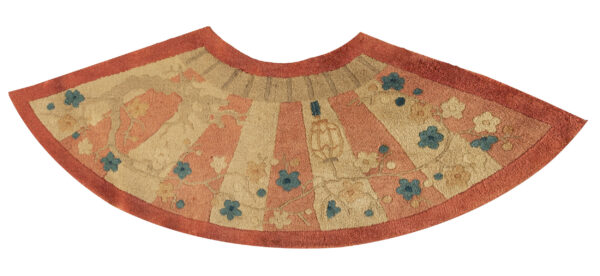 Semi-circular rug with rust and beige radial stripes, detailed with blue and gold floral patterns.