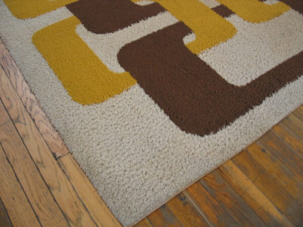 Brown, yellow, and beige high-pile rug with a geometric pattern on wood flooring.