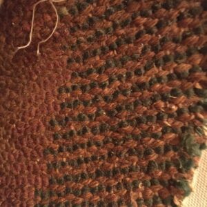 Woven texture showing alternating rows of prominent rustic brown loops and dark green knots.