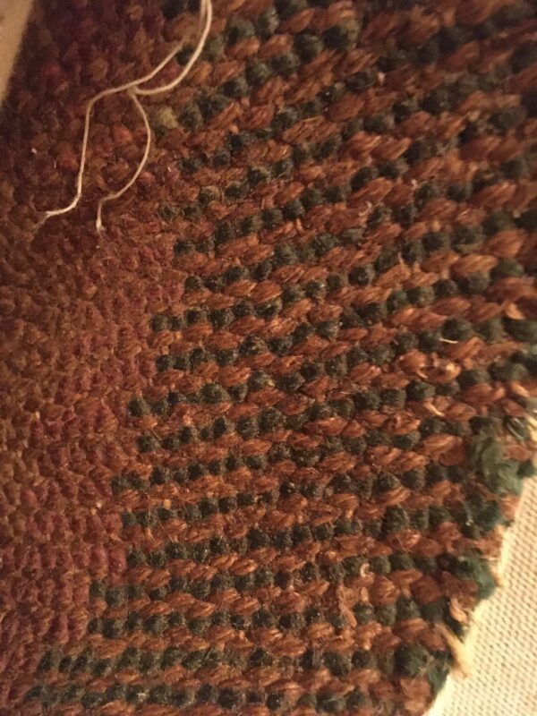 Woven texture showing alternating rows of prominent rustic brown loops and dark green knots.