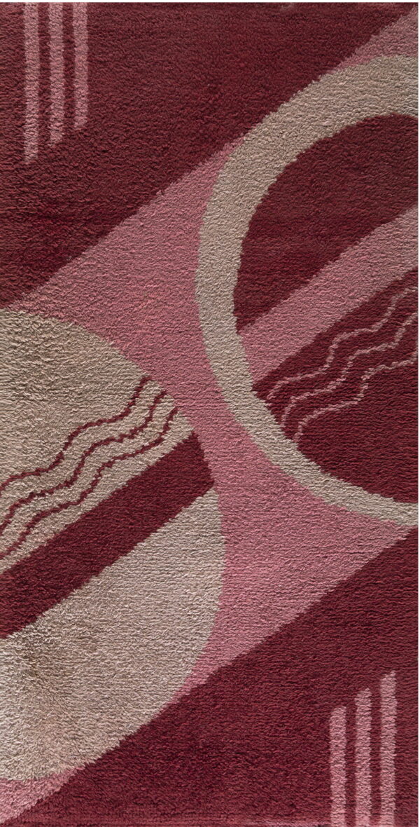 Textured rug featuring geometric burgundy, pink, and beige shapes with wavy lines and stripes.