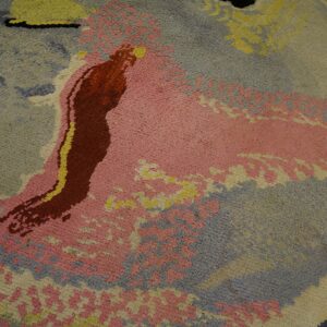 Abstract medium pile rug detail featuring large fields of pink, dusty blue, yellow, and deep red.