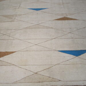 Beige flatweave rug featuring a diamond grid pattern highlighted with scattered brown and bright blue shapes.