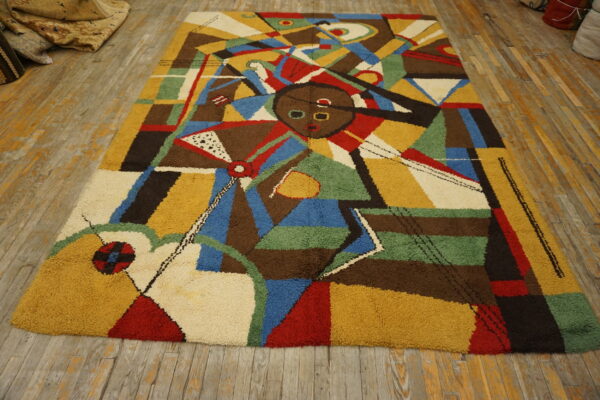 Colorful shaggy rug with an abstract face design and geometric shapes on distressed wood flooring.