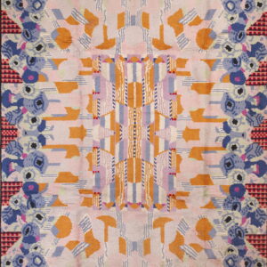 Textured rug displaying a complex symmetrical pattern of orange, pink, blue, lavender, and checkered motifs.