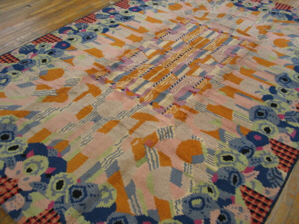 High-pile rug in bright pink, orange, blue, and green abstract patterns rests on hardwood flooring.