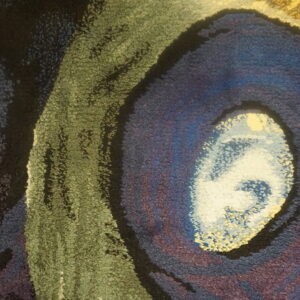 Textured close-up of a rug featuring an abstract eye-like pattern in blue, purple, olive green, and black.