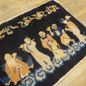 Navy rug with a multicolor figural pattern of people standing on blue clouds, displayed on light plank flooring.