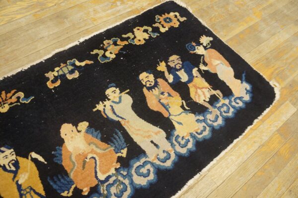 Navy rug with a multicolor figural pattern of people standing on blue clouds, displayed on light plank flooring.