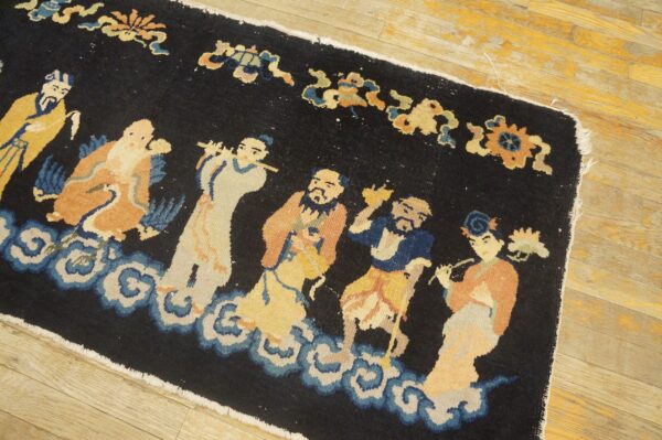 Navy rug with low pile depicts figures in yellow, orange, and blue standing on white clouds on wood planks.