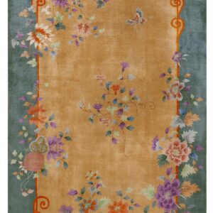 Gold field rug with a teal border and a colorful pattern of stylized flowers and butterflies.