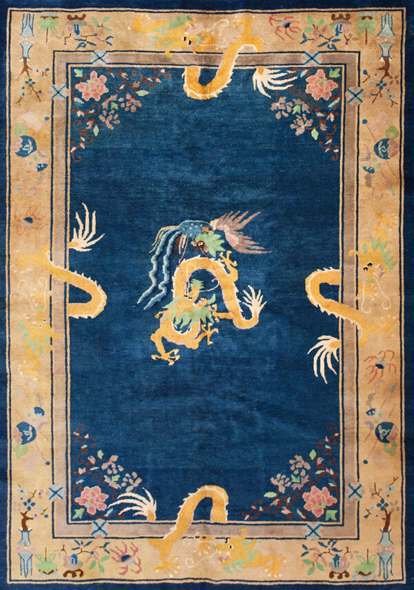 Deep blue rug with an ornate golden dragon pattern and light tan border containing floral and vase motifs.