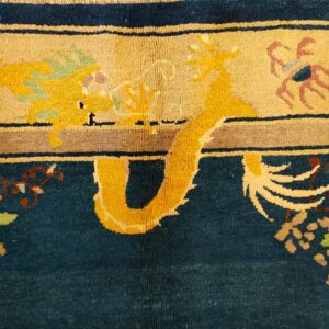 Teal and tan rug detail showing a bright yellow dragon motif, floral accents, and a shaggy medium pile.