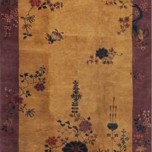 Golden yellow rug with a wide purple border decorated with winding floral branches and birds.