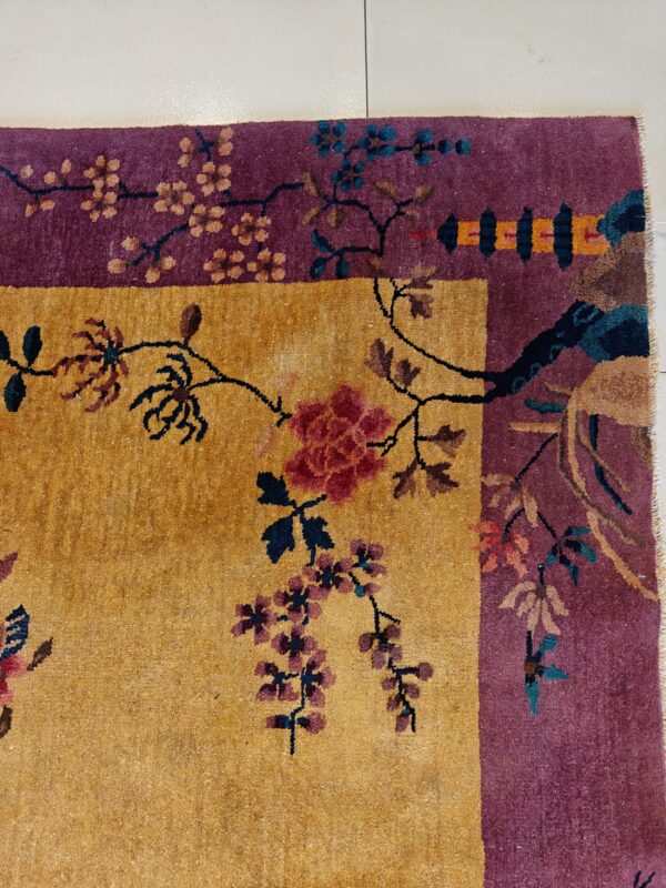 Golden yellow field and deep purple border rug featuring detailed floral and vine motifs on tile.