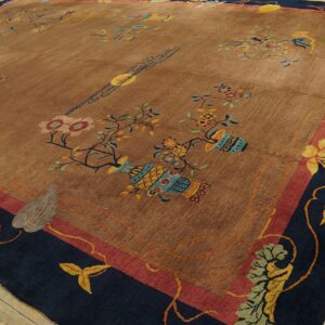 Shimmering tan rug with colorful floral and vase motifs, featuring wide navy and red borders on wood planks.