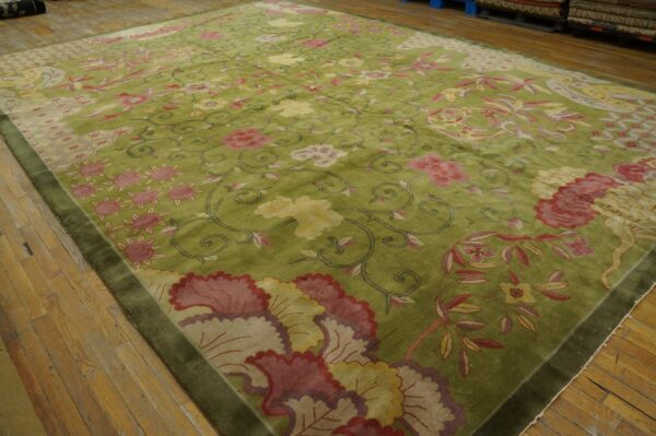 Shaggy green rug with scrolling pink and yellow floral patterns resting on light wood flooring.
