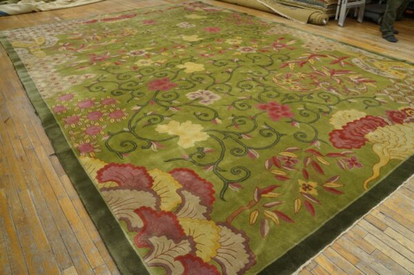Chartreuse green rug featuring red and yellow floral scrollwork, bordered in dark olive, laid on wood floors.
