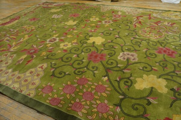 Low-pile lime green rug featuring a dense scrolling floral pattern in pink and yellow on wood flooring.