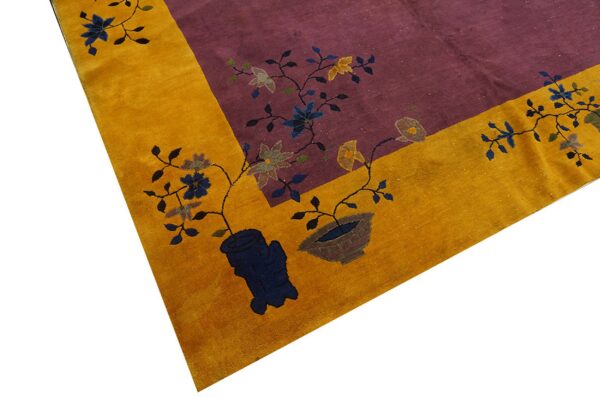 Purple rug field and golden border detailed with stylized blue and yellow potted floral designs.