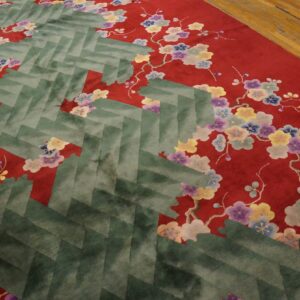 A close-up shows a red rug with multicolored floral designs and a central green herringbone pattern.