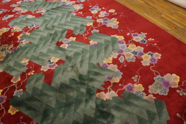 A close-up shows a red rug with multicolored floral designs and a central green herringbone pattern.