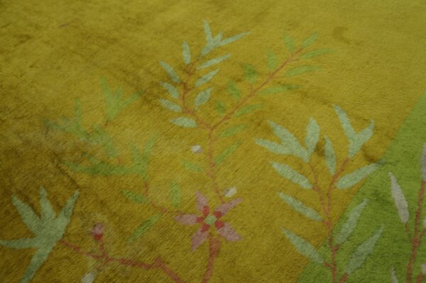 Close-up of a high-pile chartreuse rug with a dense pattern of stylized green and pink botanical branches.