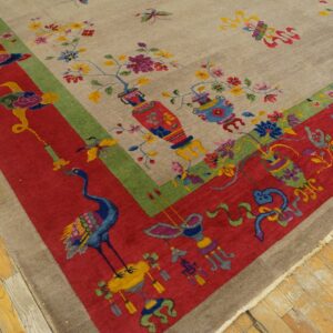 Multicolored rug corner with a beige field, floral vases, and a wide red border showing a crane on wood floor.