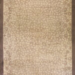 Low-pile beige and taupe rug featuring an all-over floral pattern and a wide dark brown border.