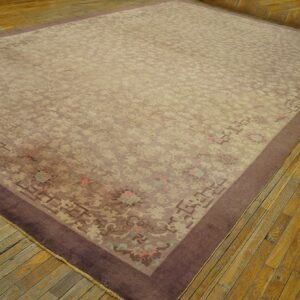 Muted lavender and beige traditional rug with a wide dark border, placed on distressed wood planks.